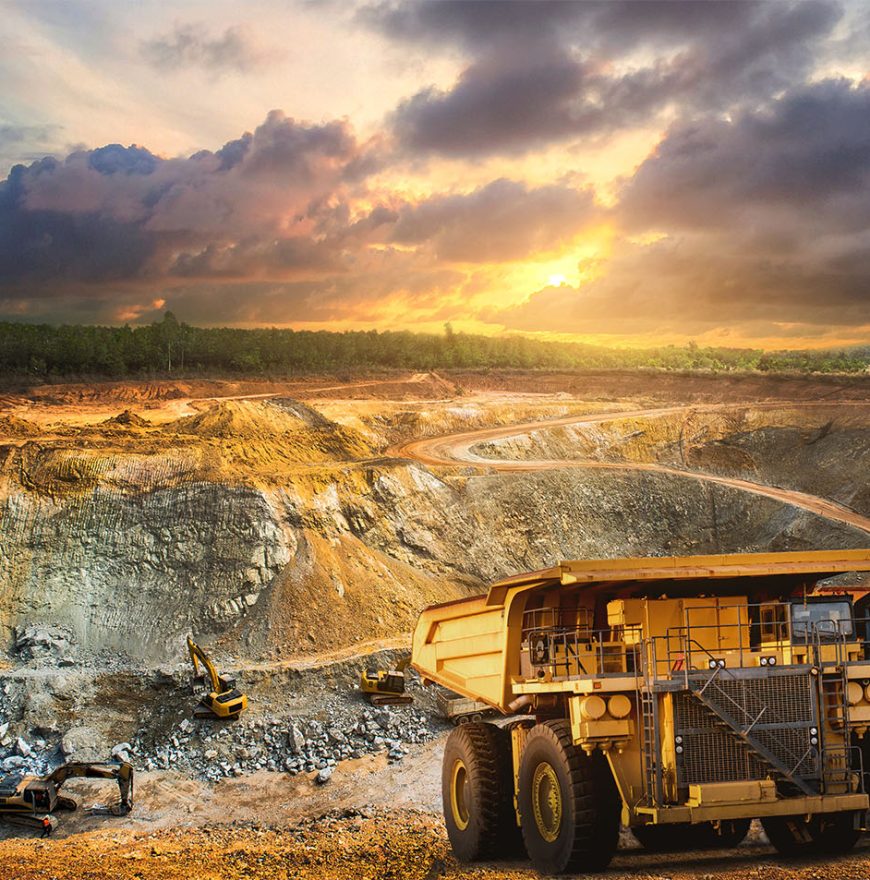 Yellow dump truck loading minerals copper, silver, gold, and other  at mining quarry.